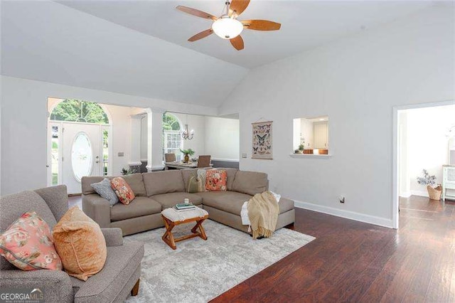living room with lofted ceiling, wood finished floors, a ceiling fan, baseboards, and a chandelier