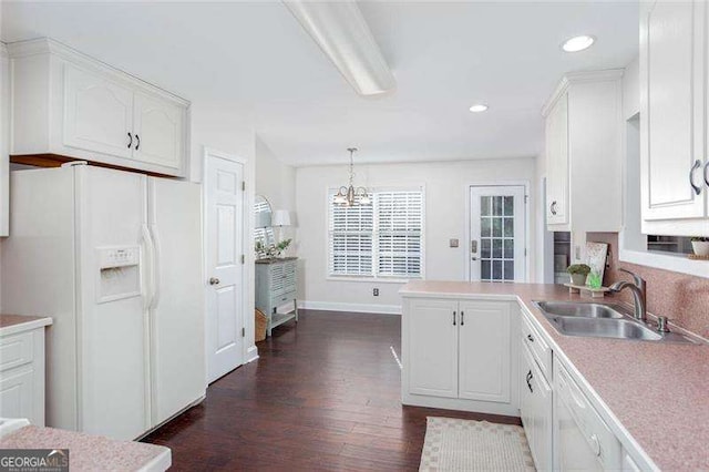 kitchen with white fridge with ice dispenser, a sink, dark wood-style flooring, white cabinets, and a chandelier