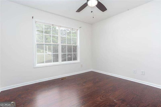 empty room with a ceiling fan, dark wood-style floors, and baseboards