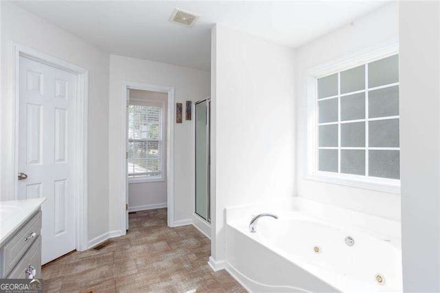 full bath with a shower stall, a tub with jets, vanity, and baseboards