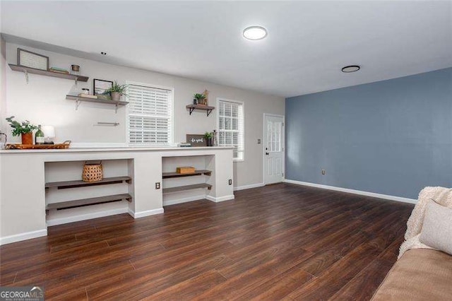 unfurnished living room with wood finished floors and baseboards