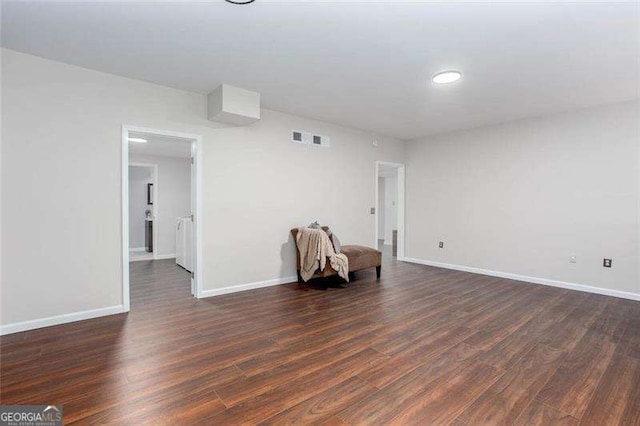 empty room featuring dark wood finished floors and baseboards
