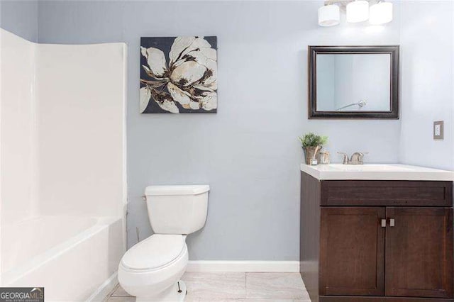 bathroom featuring toilet, baseboards, and vanity