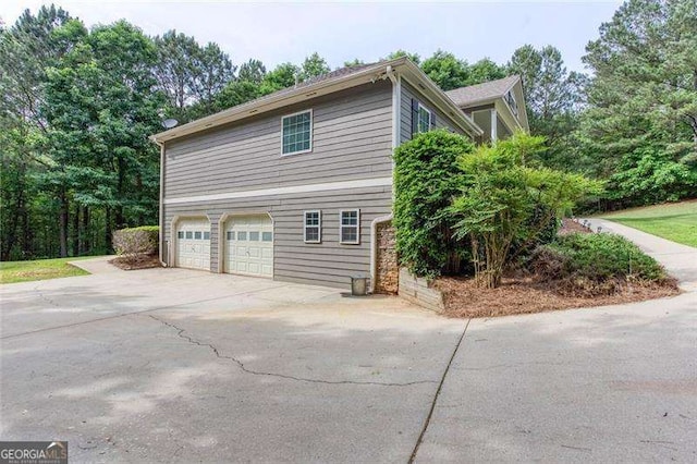 view of home's exterior with concrete driveway and a garage