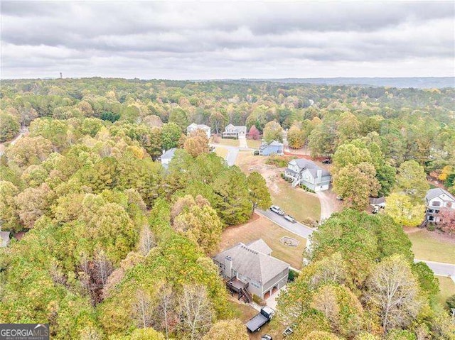 aerial view of property's location featuring a forest
