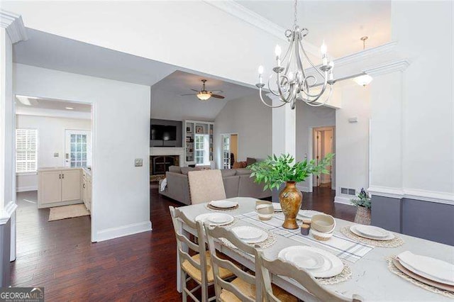 dining area featuring a ceiling fan, dark wood finished floors, baseboards, a fireplace, and a chandelier