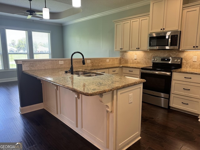 293 Laurel Landing Blvd, Kingsland, GA 31548 - kitchen featuring appliances with stainless steel finishes, a sink, dark wood-style flooring, a kitchen breakfast bar, and crown molding