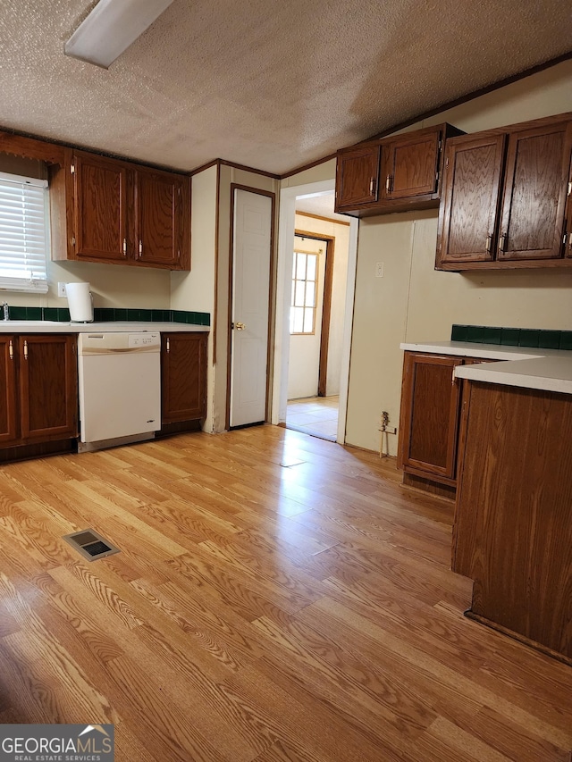 715 Bailey Jester Rd, Griffin, GA 30224 - kitchen with dishwasher, light wood finished floors, healthy amount of natural light, a textured ceiling, and light countertops