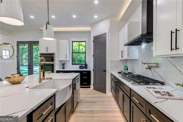 136 Beutell St, Norcross, GA 30071 - kitchen with wall chimney range hood, appliances with stainless steel finishes, white cabinetry, a sink, and light stone countertops