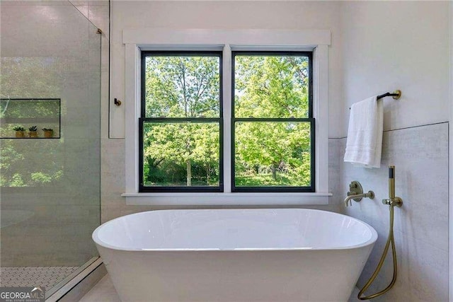 136 Beutell St, Norcross, GA 30071 - full bathroom featuring plenty of natural light, a soaking tub, a tile shower, and tile walls
