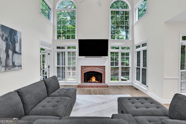 870 River Cliff Ct, Suwanee, GA 30024 - living area with a towering ceiling, wood finished floors, a brick fireplace, and baseboards