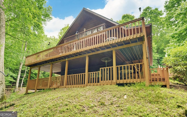 rear view of house featuring a wooden deck