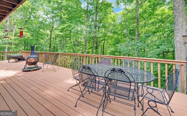 wooden deck with a fire pit and outdoor dining area