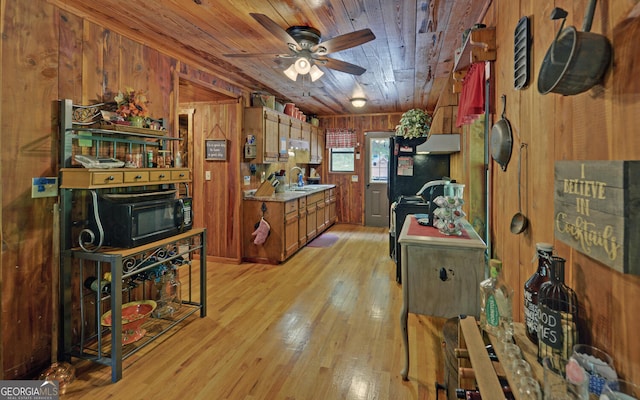 kitchen featuring black microwave, wooden walls, wooden ceiling, a ceiling fan, and brown cabinets