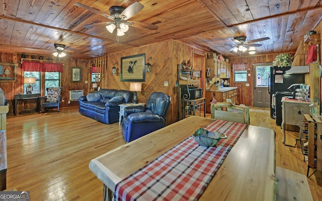 dining room featuring wood ceiling, a ceiling fan, wood walls, wood finished floors, and a wood stove