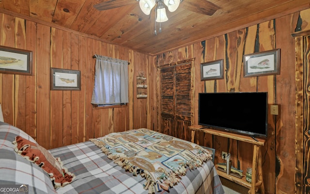 bedroom featuring wooden ceiling, wooden walls, carpet floors, and a ceiling fan
