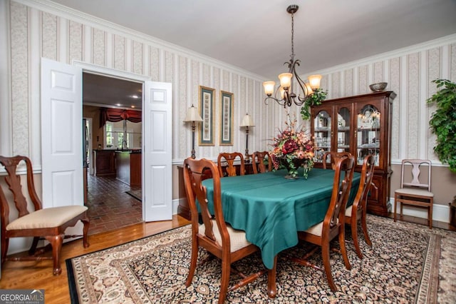 98 Sweetbriar Ln, Carrollton, GA 30117 - dining area with wallpapered walls, a chandelier, ornamental molding, and brick patterned flooring