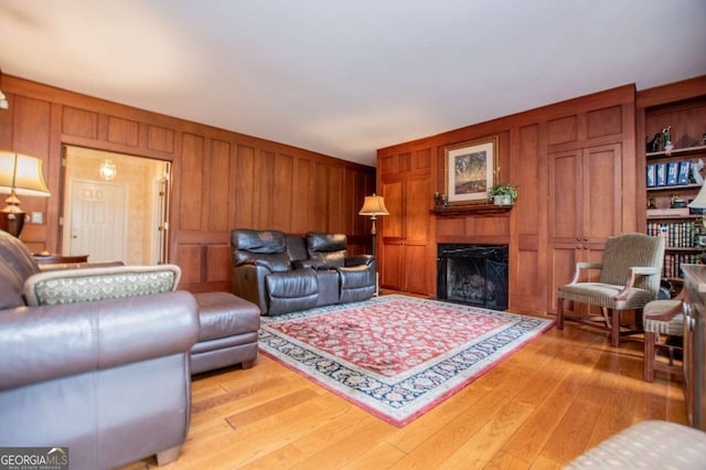 98 Sweetbriar Ln, Carrollton, GA 30117 - living room with light wood-type flooring, wooden walls, and a fireplace