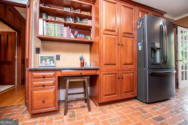 98 Sweetbriar Ln, Carrollton, GA 30117 - kitchen with stainless steel fridge, brick flooring, ornamental molding, brown cabinets, and dark stone countertops