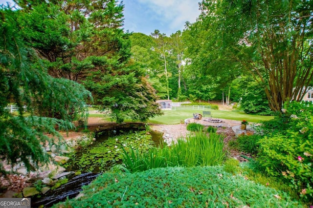 98 Sweetbriar Ln, Carrollton, GA 30117 - view of community featuring an outdoor fire pit, a lawn, and a view of trees
