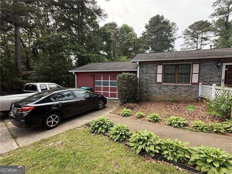 2857 Spanish Oak Dr SW, Lilburn, GA 30047 - view of front facade featuring concrete driveway and brick siding