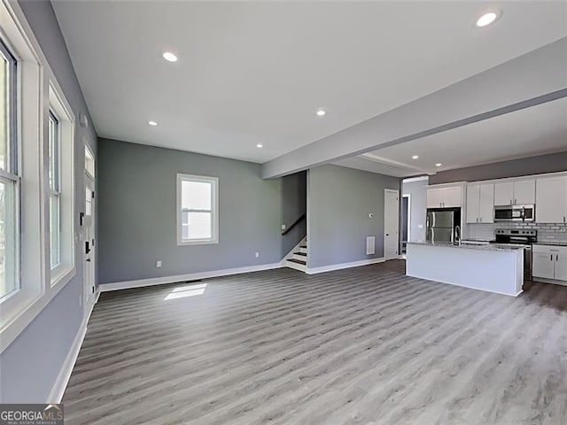 629 Windsor St, Atlanta, GA 30312 - unfurnished living room with light wood-style flooring, stairs, and recessed lighting