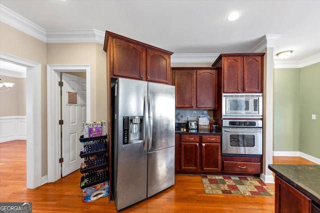 101 Lumby Ln, Stockbridge, GA 30281 - kitchen featuring appliances with stainless steel finishes, crown molding, wood finished floors, decorative backsplash, and dark stone countertops