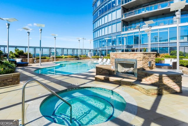 3344 Peachtree Rd NE Unit 3601, Atlanta, GA 30326 - community pool featuring a community hot tub, a patio, and an outdoor stone fireplace