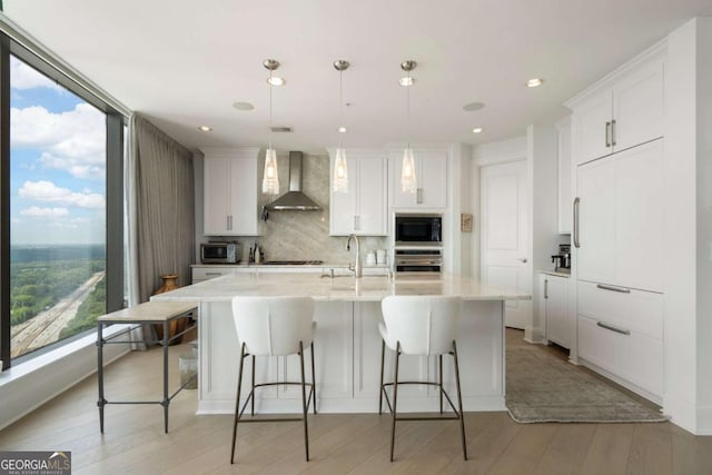 3344 Peachtree Rd NE Unit 3601, Atlanta, GA 30326 - kitchen featuring wall chimney range hood, appliances with stainless steel finishes, a sink, plenty of natural light, and recessed lighting