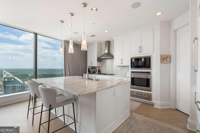 3344 Peachtree Rd NE Unit 3601, Atlanta, GA 30326 - kitchen with oven, a sink, wall chimney exhaust hood, a warming drawer, and black microwave