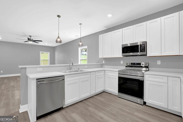 3614 Griffin Dr, Gainesville, GA 30506 - kitchen with stainless steel appliances, a sink, a peninsula, light wood-type flooring, and ceiling fan