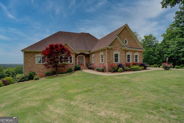 view of front facade featuring brick siding and a front yard