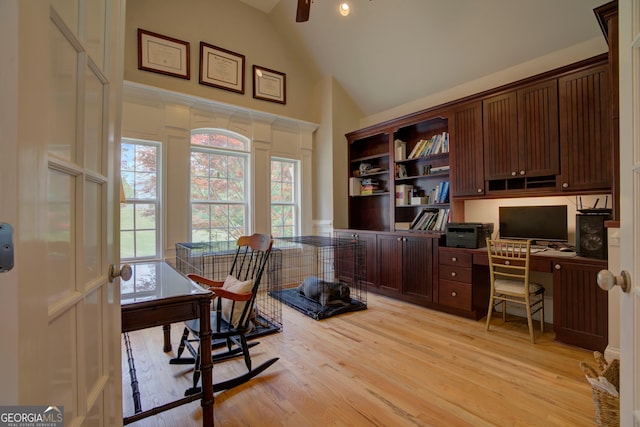 home office with high vaulted ceiling, light wood finished floors, and healthy amount of natural light