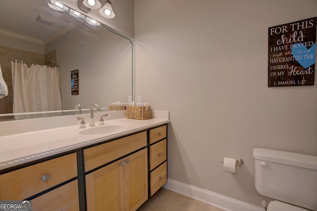 bathroom with tile patterned floors, vanity, toilet, crown molding, and baseboards