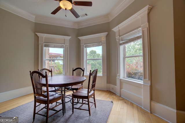 dining room with light wood-type flooring, ceiling fan, and ornamental molding