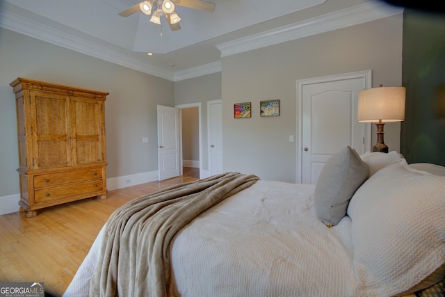 bedroom with ornamental molding, light wood finished floors, ceiling fan, and baseboards