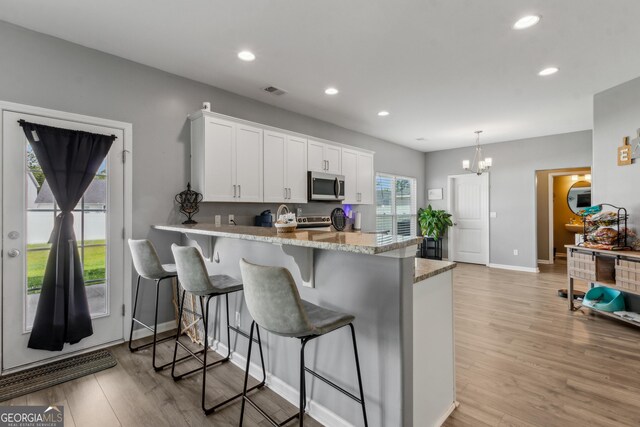 103 Olson Way, Kingsland, GA 31548 - kitchen featuring stainless steel microwave, white cabinetry, light wood-style flooring, recessed lighting, and baseboards