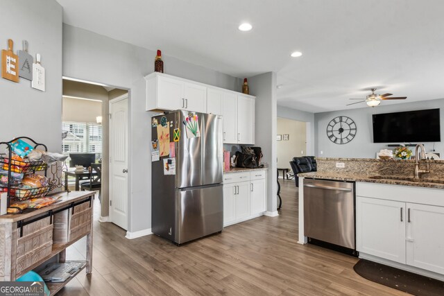 103 Olson Way, Kingsland, GA 31548 - kitchen with stainless steel appliances, a sink, ceiling fan, stone counters, and light wood finished floors
