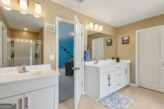 103 Olson Way, Kingsland, GA 31548 - bathroom with two vanities, a shower stall, tile patterned flooring, and baseboards