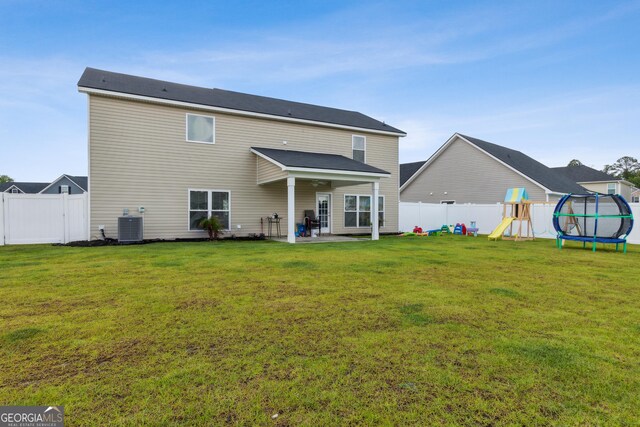 103 Olson Way, Kingsland, GA 31548 - back of property with a playground, central air condition unit, a patio area, and a trampoline