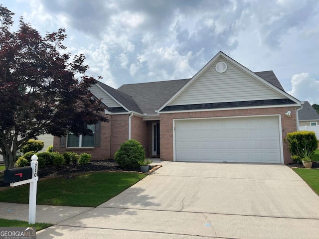 710 Village Ln, Loganville, GA 30052 - view of front facade with driveway, a garage, brick siding, and a front lawn