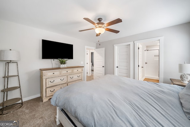 carpeted bedroom featuring baseboards, ceiling fan, and ensuite bathroom