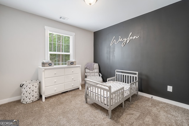 carpeted bedroom with a nursery area and baseboards