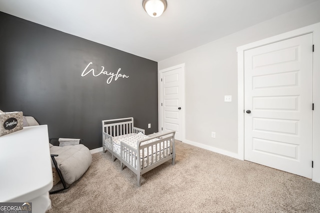 bedroom featuring carpet flooring, baseboards, and a nursery area
