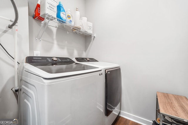 washroom featuring washing machine and clothes dryer, dark wood finished floors, and baseboards