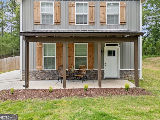 property entrance featuring stone siding, a porch, and board and batten siding