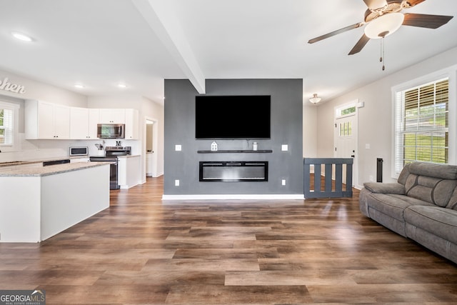 living area featuring dark wood finished floors, recessed lighting, baseboards, ceiling fan, and a glass covered fireplace