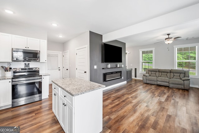 kitchen featuring appliances with stainless steel finishes, dark wood-style floors, open floor plan, white cabinetry, and recessed lighting