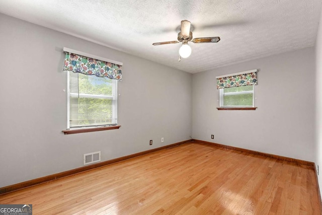 57 Fair Oaks Dr SE, Conyers, GA 30094 - unfurnished room featuring healthy amount of natural light, light wood-style flooring, baseboards, and a textured ceiling