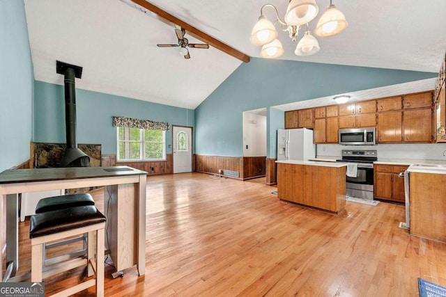 57 Fair Oaks Dr SE, Conyers, GA 30094 - kitchen with appliances with stainless steel finishes, a center island, brown cabinetry, wainscoting, and open floor plan